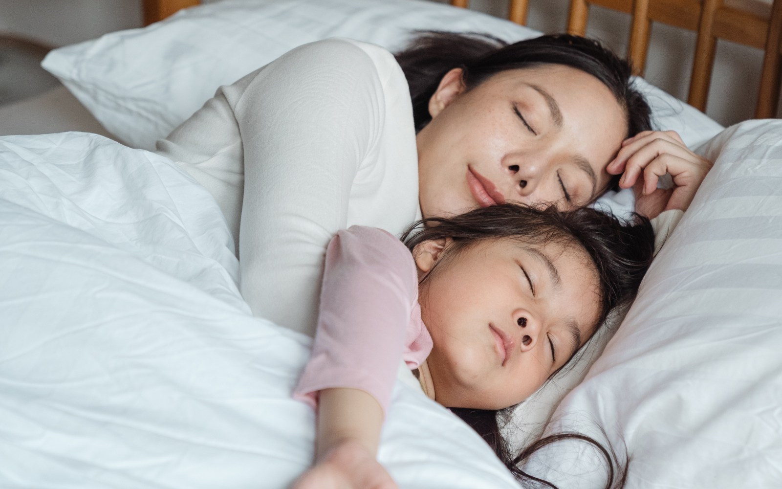 mother and child sleeping in bed together